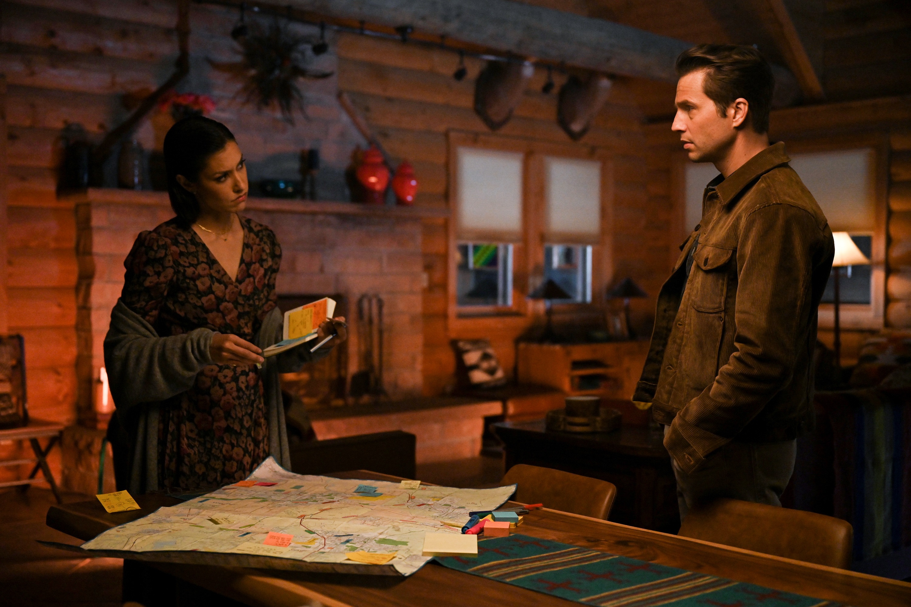 'Big Sky' cast members Janina Gavankar as Ren and Logan Marshall-Green as Travis looking at each other over a map