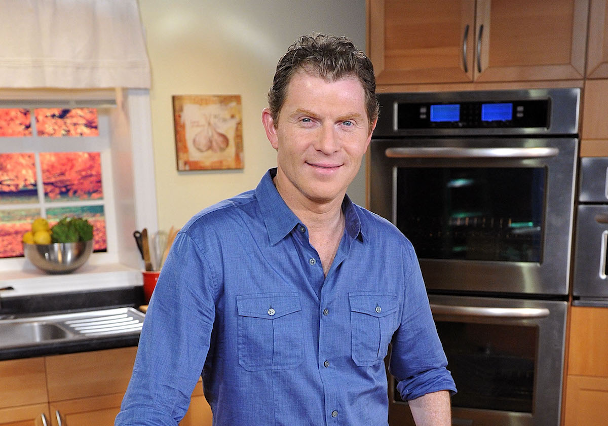 Bobby Flay, who has a recipe for Bulgur Salad, smiles in a kitchen wearing a blue shirt
