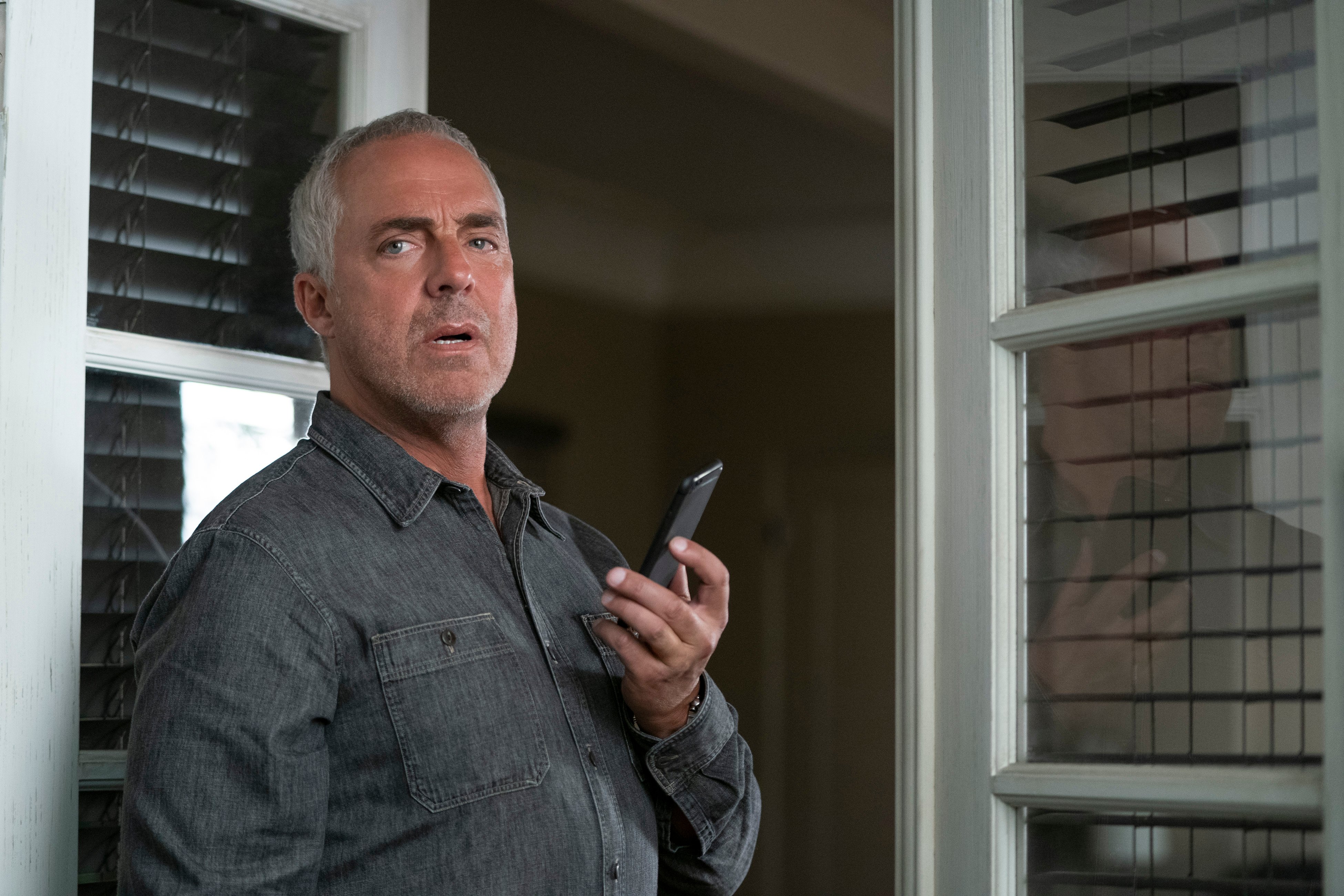Harry Bosch holding cell phone on 'Bosch: Legacy'