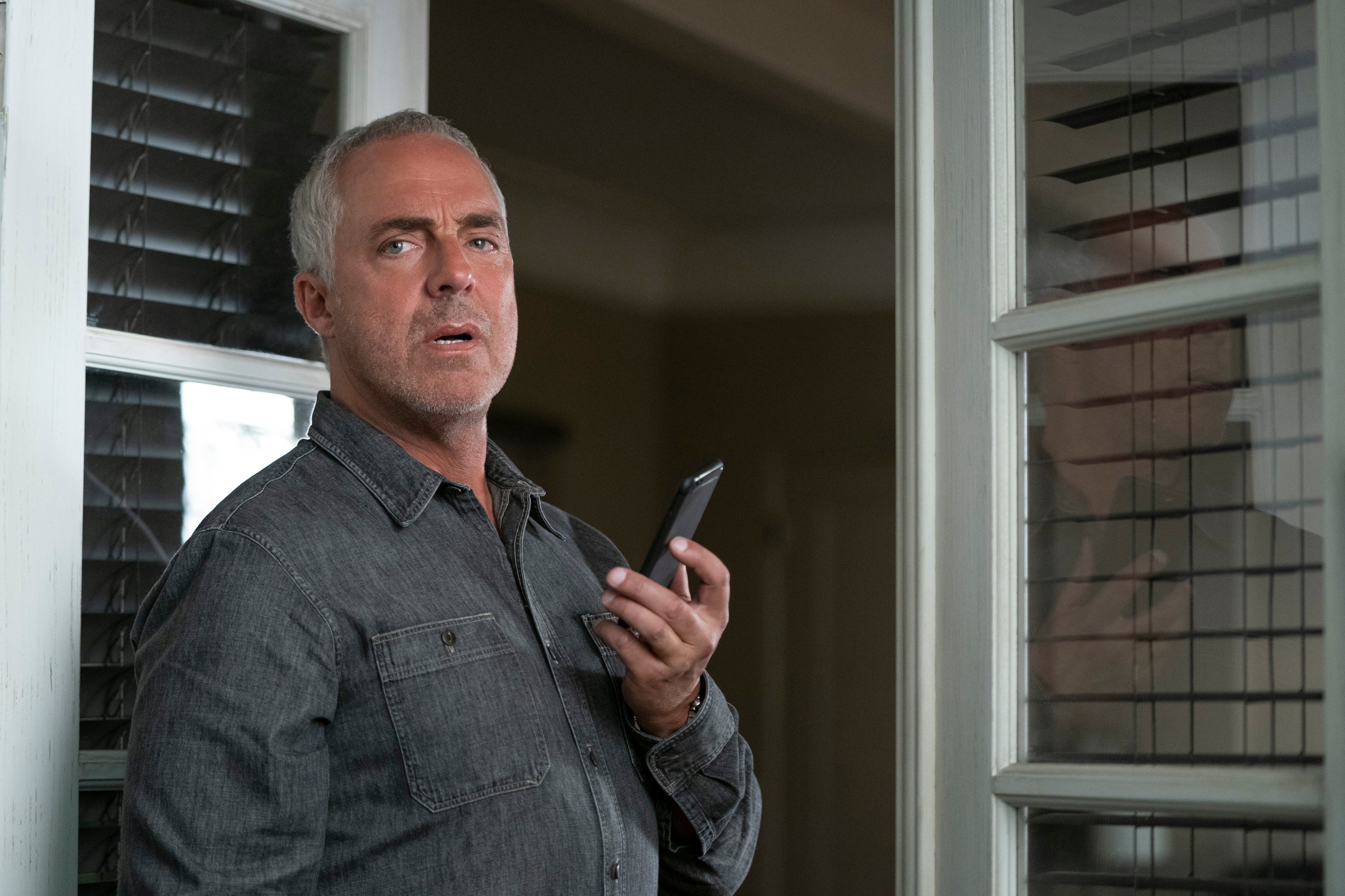 Harry Bosch talking on spearkphone in the 'Bosch' spinoff 'Bosch: Legacy'