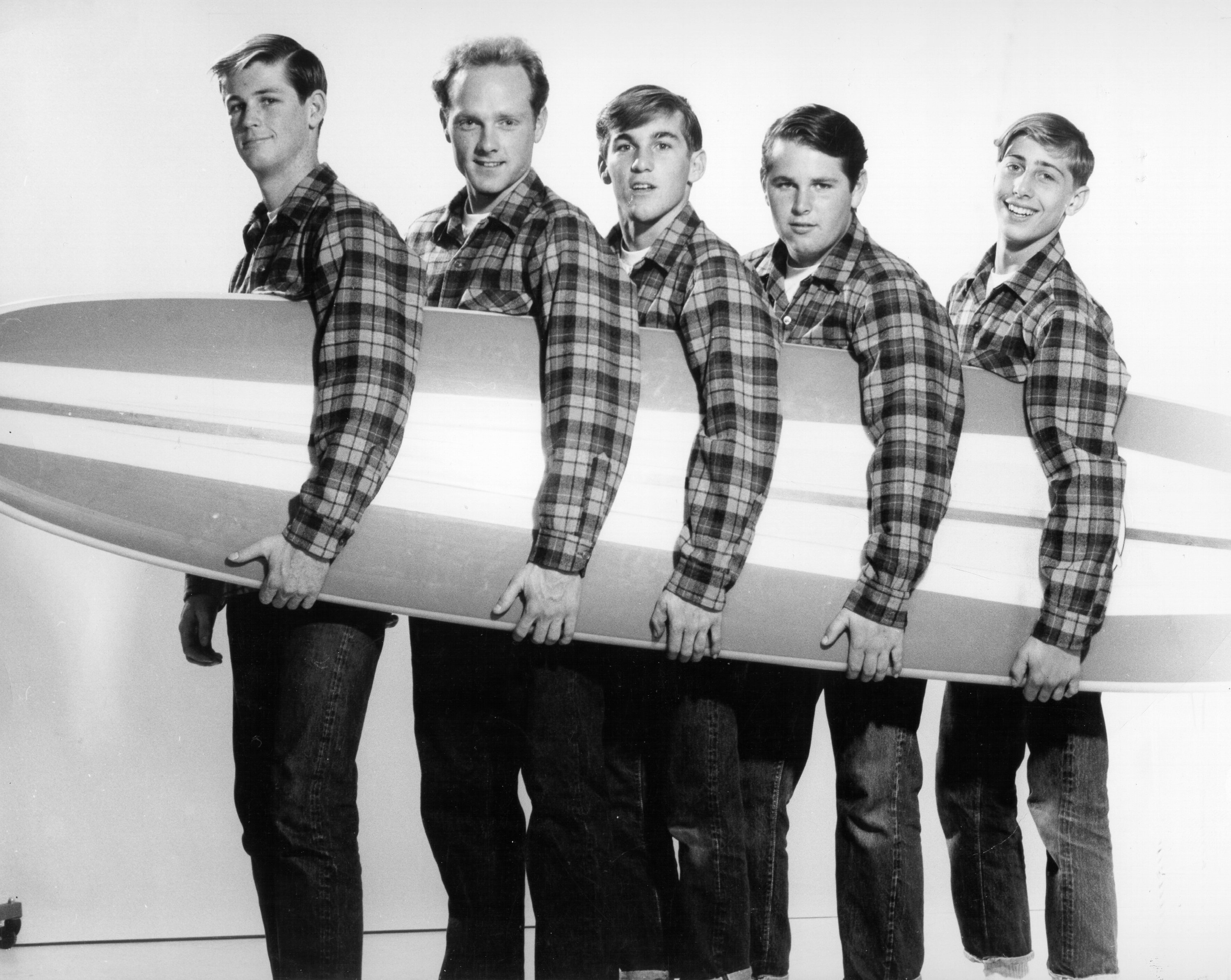 The Beach Boys holding a surf board