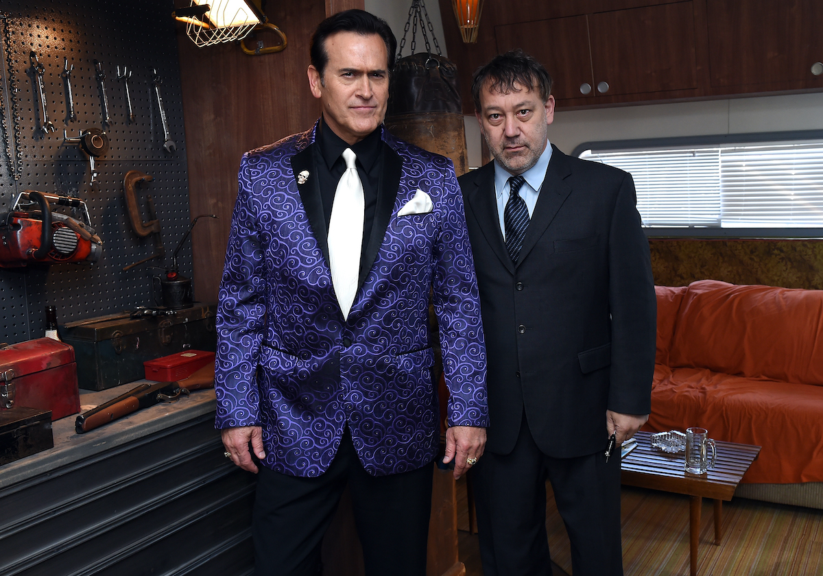 Bruce Campbell and Sam Raimi wear suits and pose