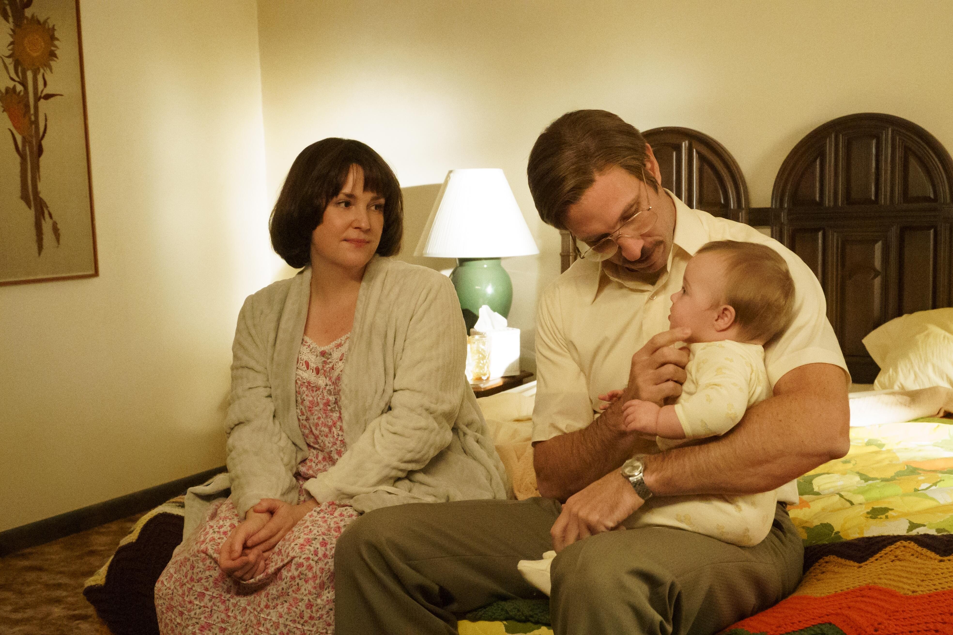 Melanie Lynskey as Betty Gore looks at Pablo Schreiber as Allan Gore while he holds their baby in 'Candy' on Hulu Episode 1