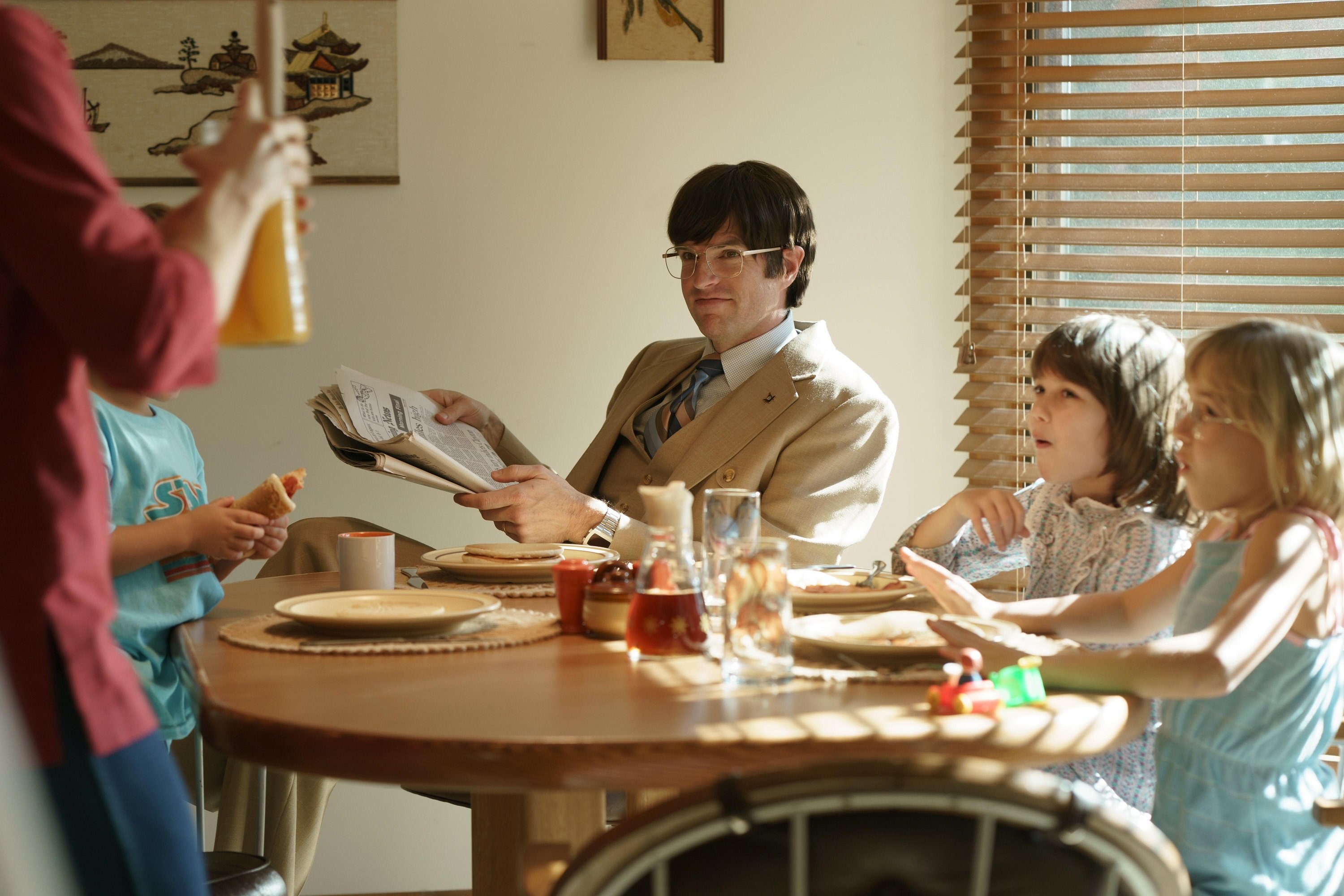 Timothy Simons smiles with a newspaper in his hand as Pat Montgomery in Hulu's 'Candy'
