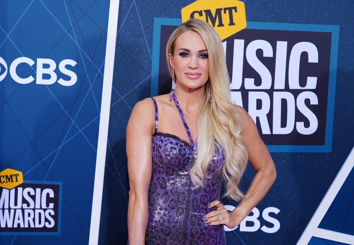 Carrie Underwood, who is scared of turtles, posing on the red carpet with her hand on her hip at the 2022 CMT Music Awards