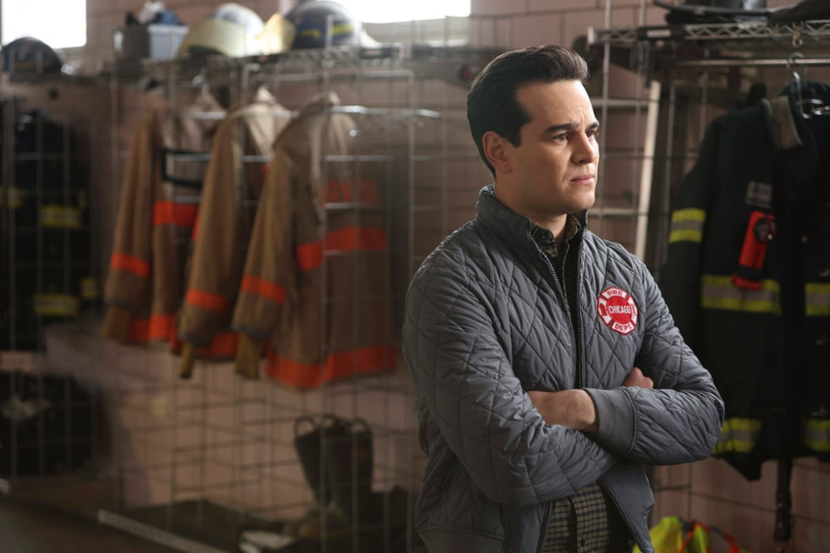 Alberto Rosende as Blake Gallo in Chicago Fire Season 10. Gallo stands with his arms folded looking concerned. 