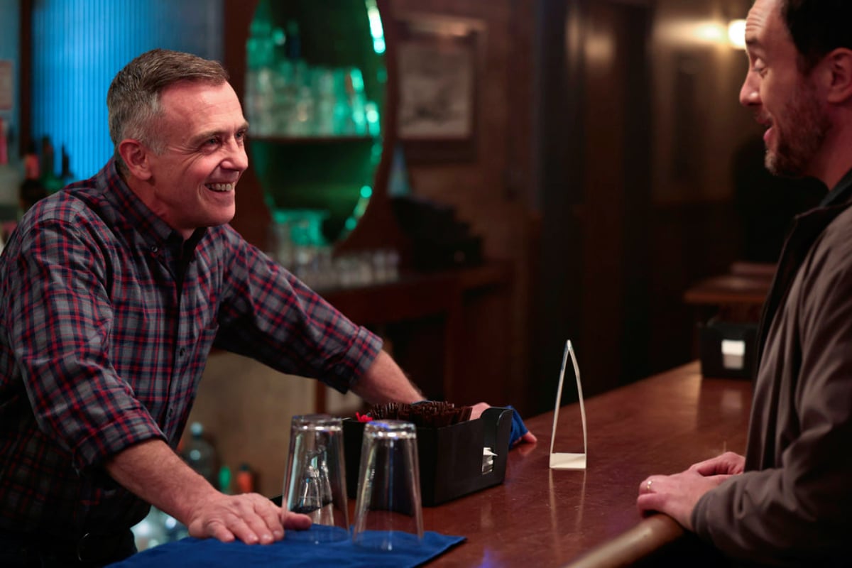 Herrmann talks with someone from behind the bar in Chicago Fire Season 10. 