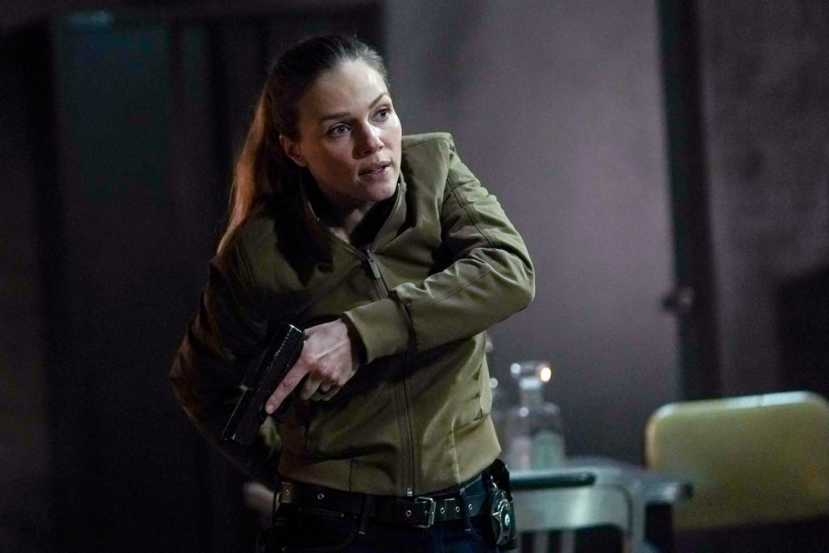 Tracy Spiridakos as Hailey in Chicago P.D. Season 9. Upton holds a gun and wears a green jacket. 