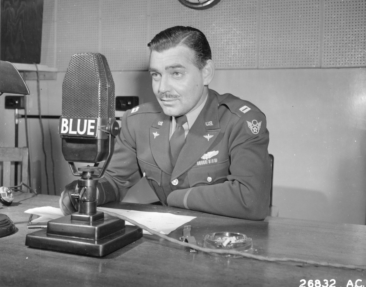 Clark Gable in front of a microphone, in black and white