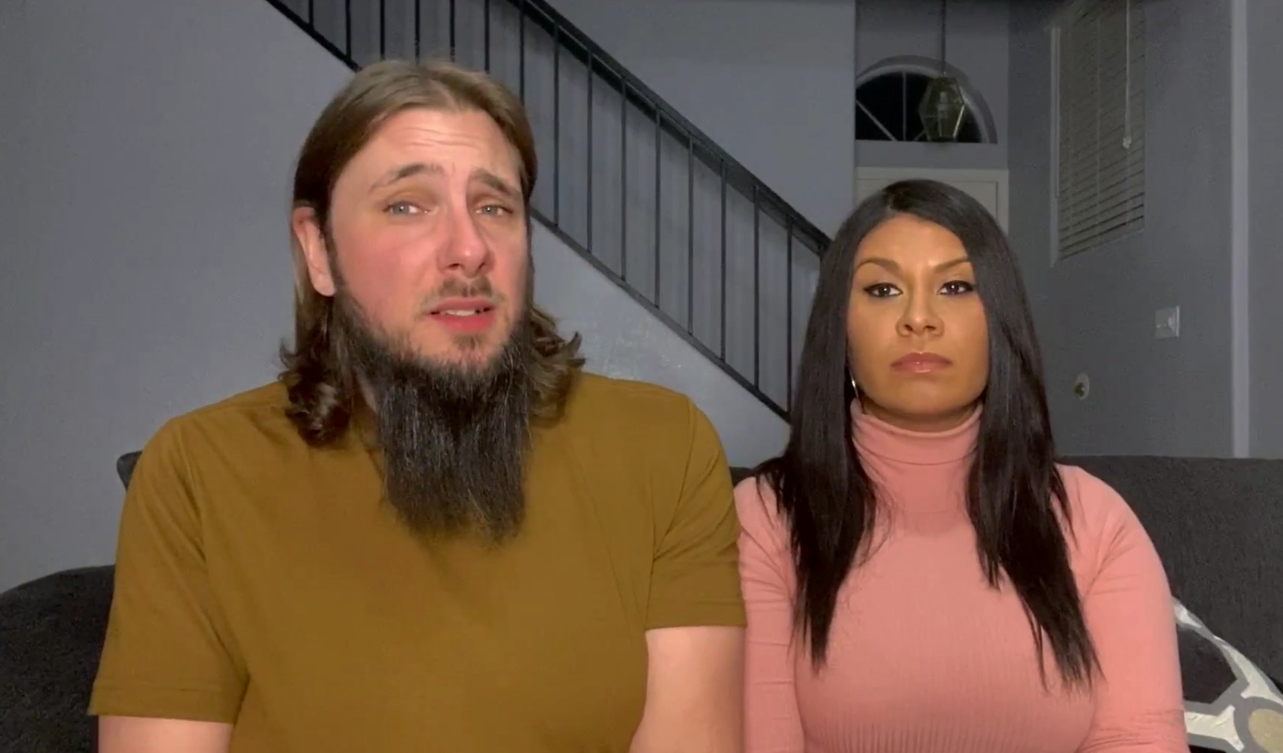 Colt Johnson wearing a brown t-shirt, sitting next to his wife, Vanessa Guerra wearing a pink turtle neck on '90 Day Diaries' on discovery+.