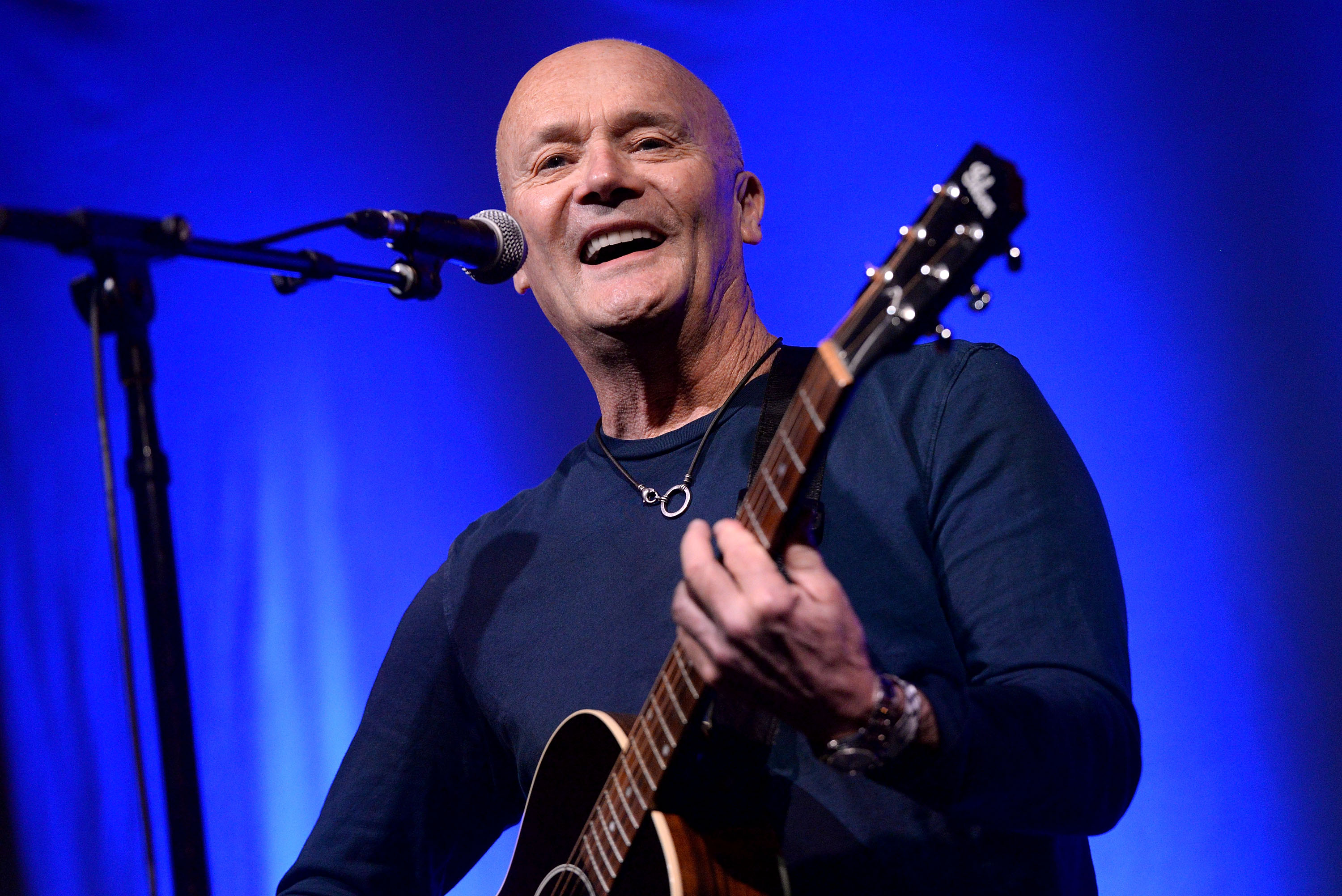 'The Office' star Creed Bratton, a former member of The Grass Roots, with a guitar on a stage
