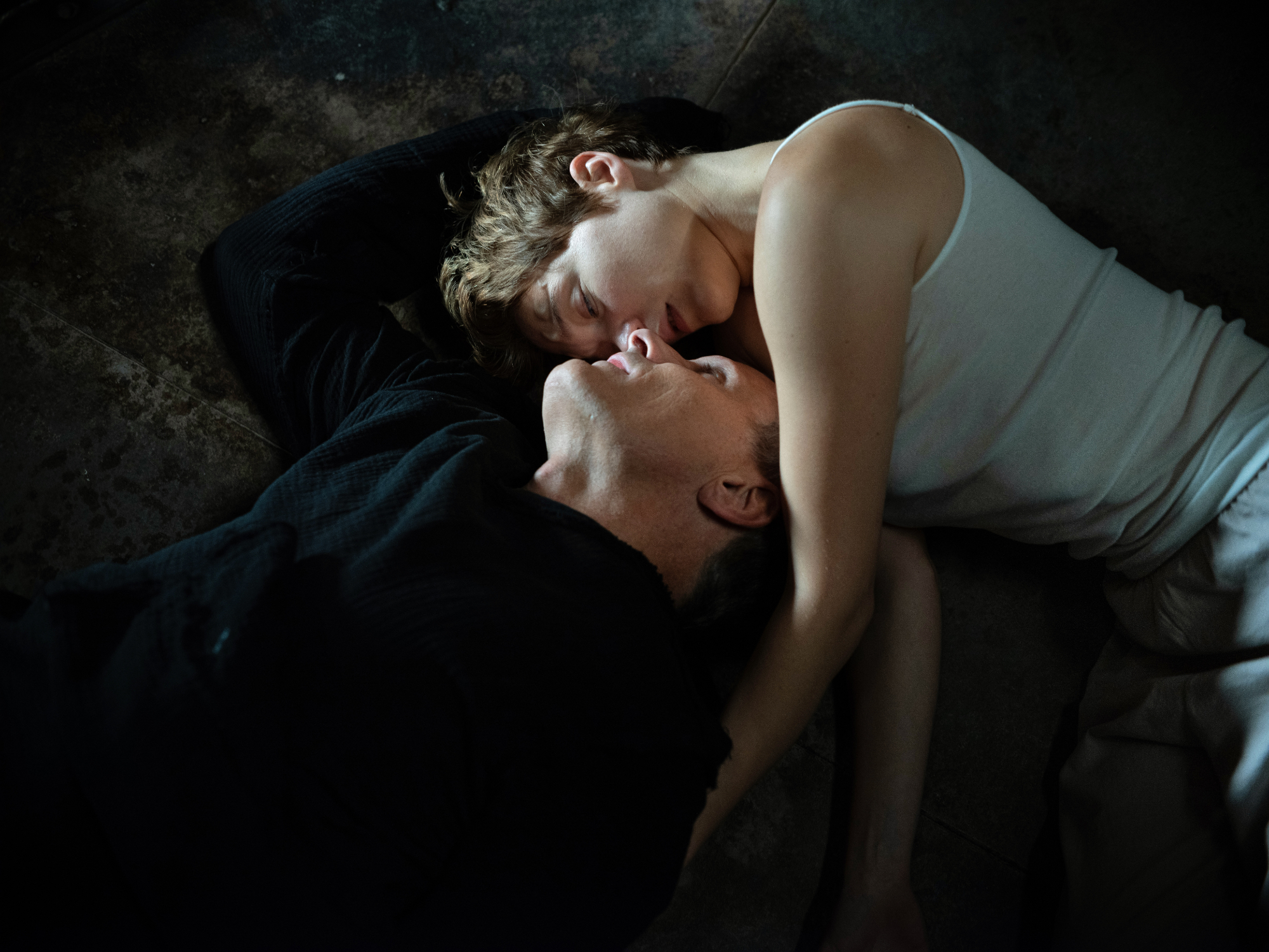 'Crimes of the Future' Viggo Mortensen as Saul Tensen and Léa Seydoux as Caprice embracing each other with Viggo looking upside down on the ground