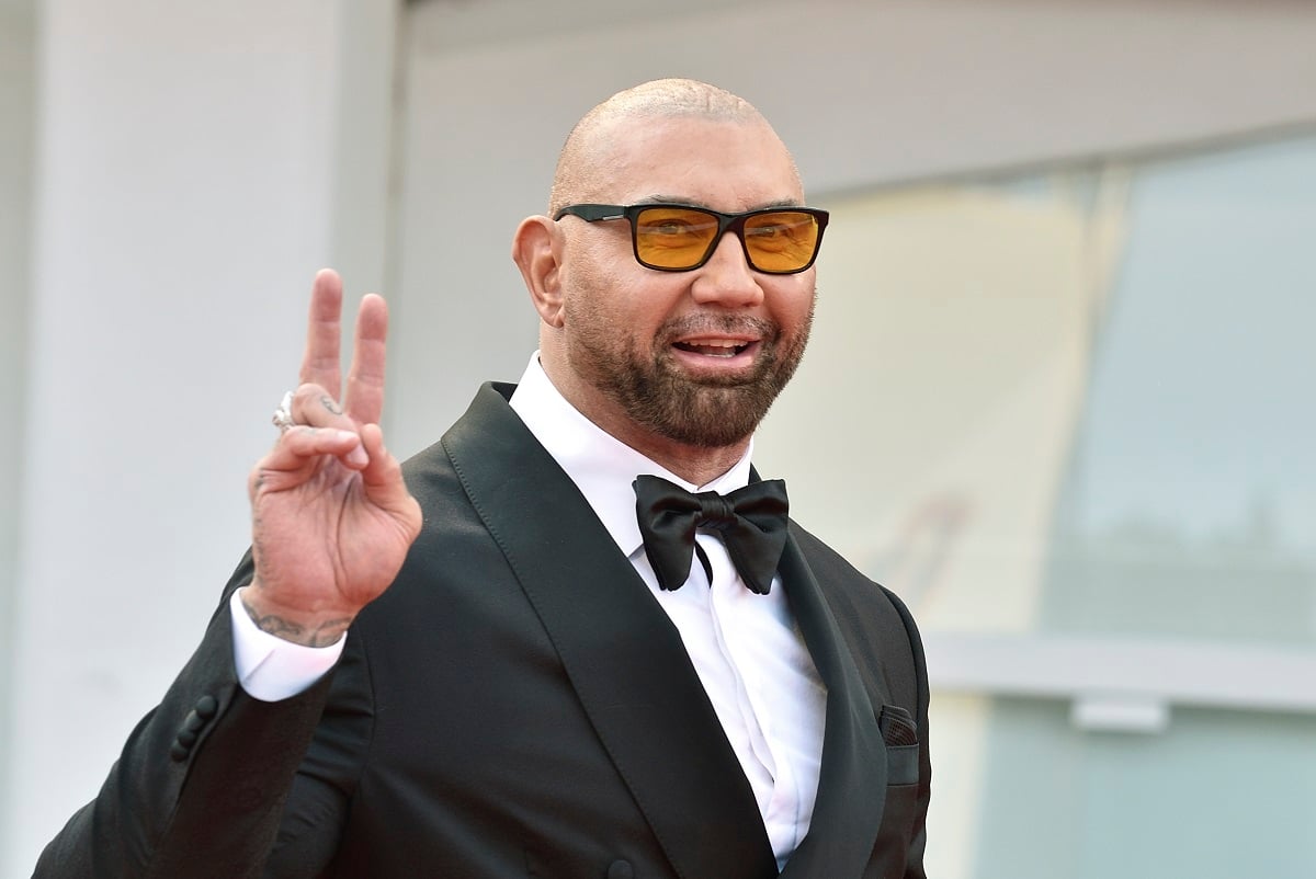 Dave Bautista smiling while wearing a suit and sunglasses.