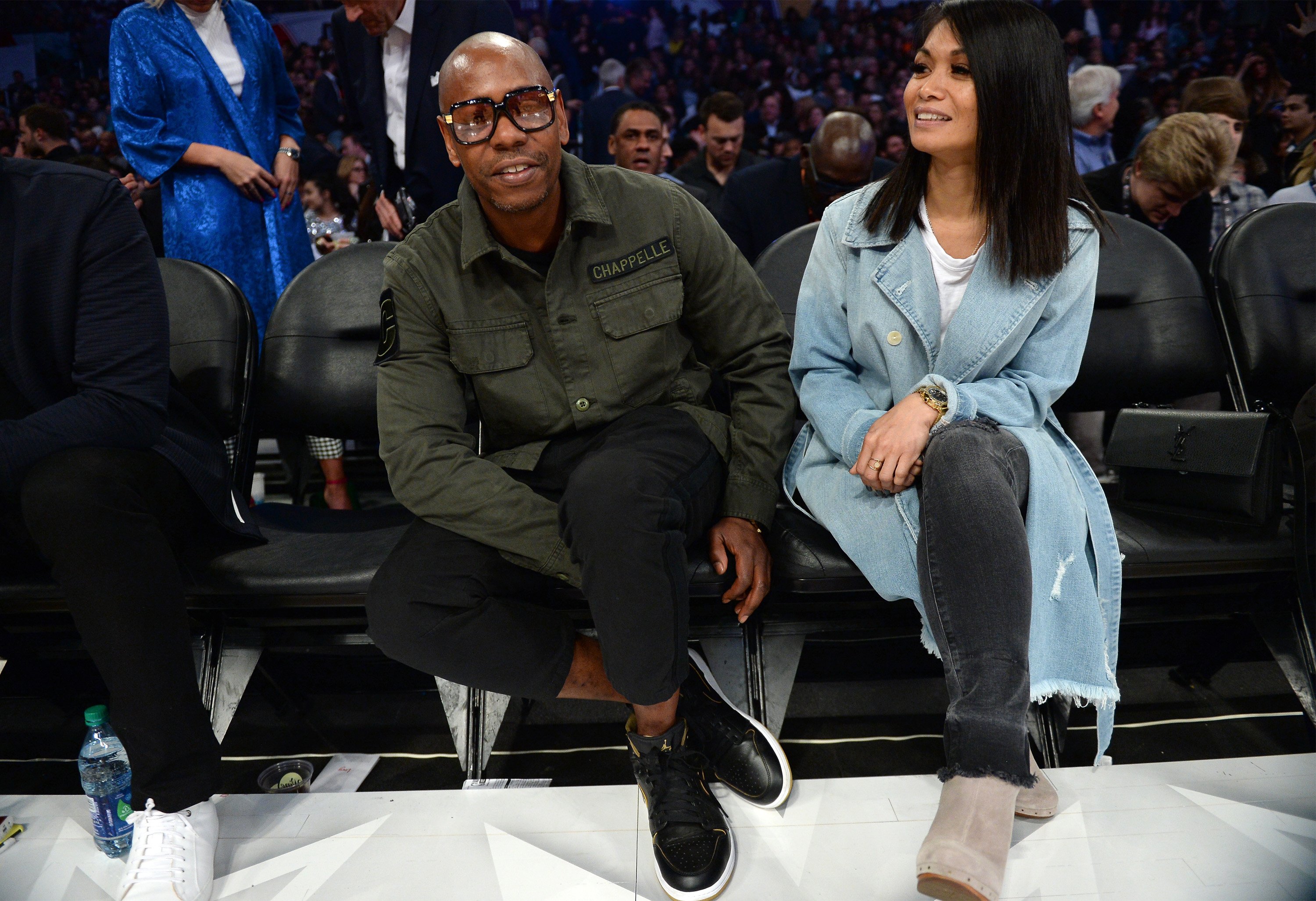 Dave Chappelle and wife Elaine sitting courtside at an NBA game