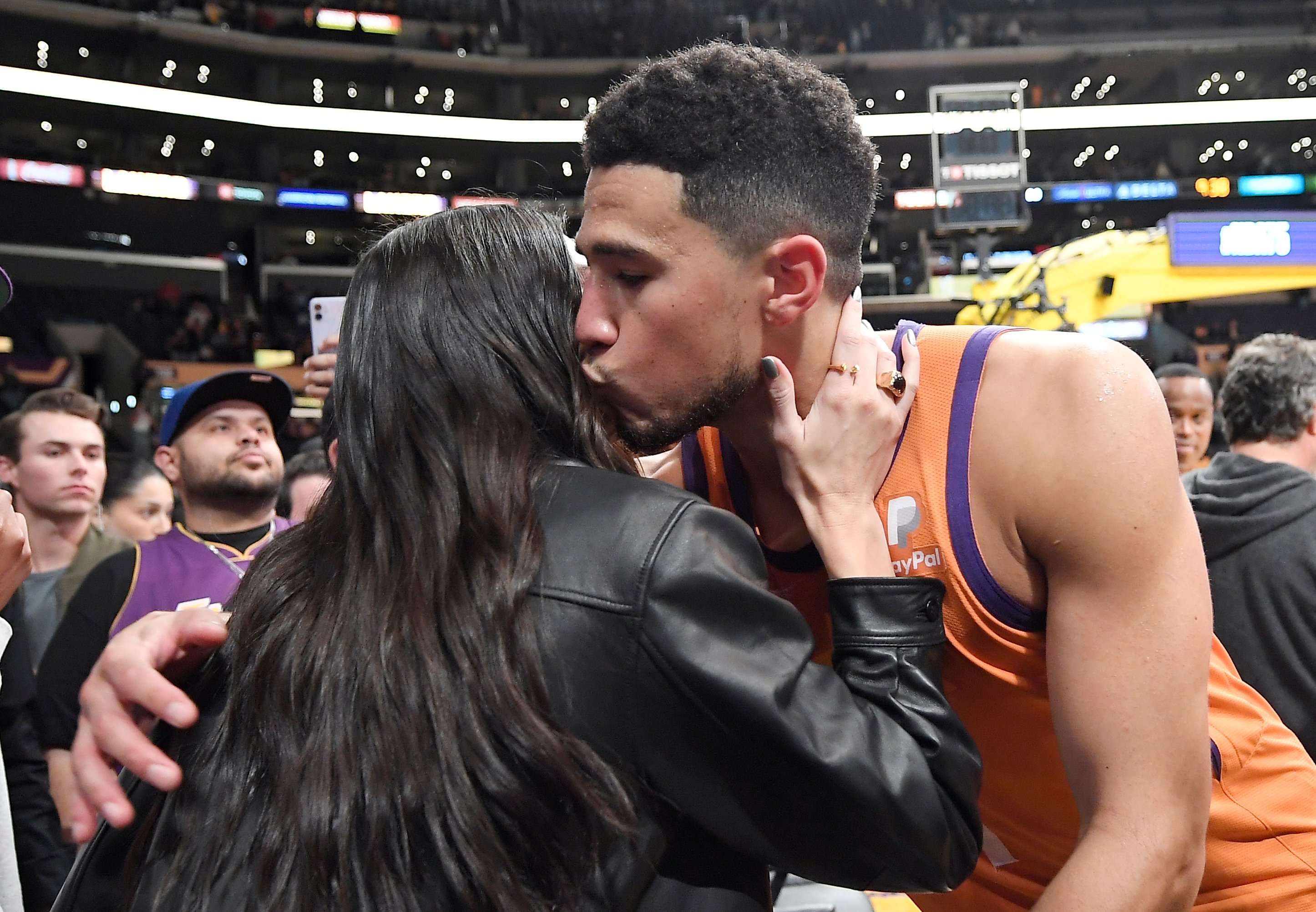 Devin Booker doesn't seem to believe in the Kardashian-Jenner curse as he kisses and hugs Kendall Jenner after a Suns game