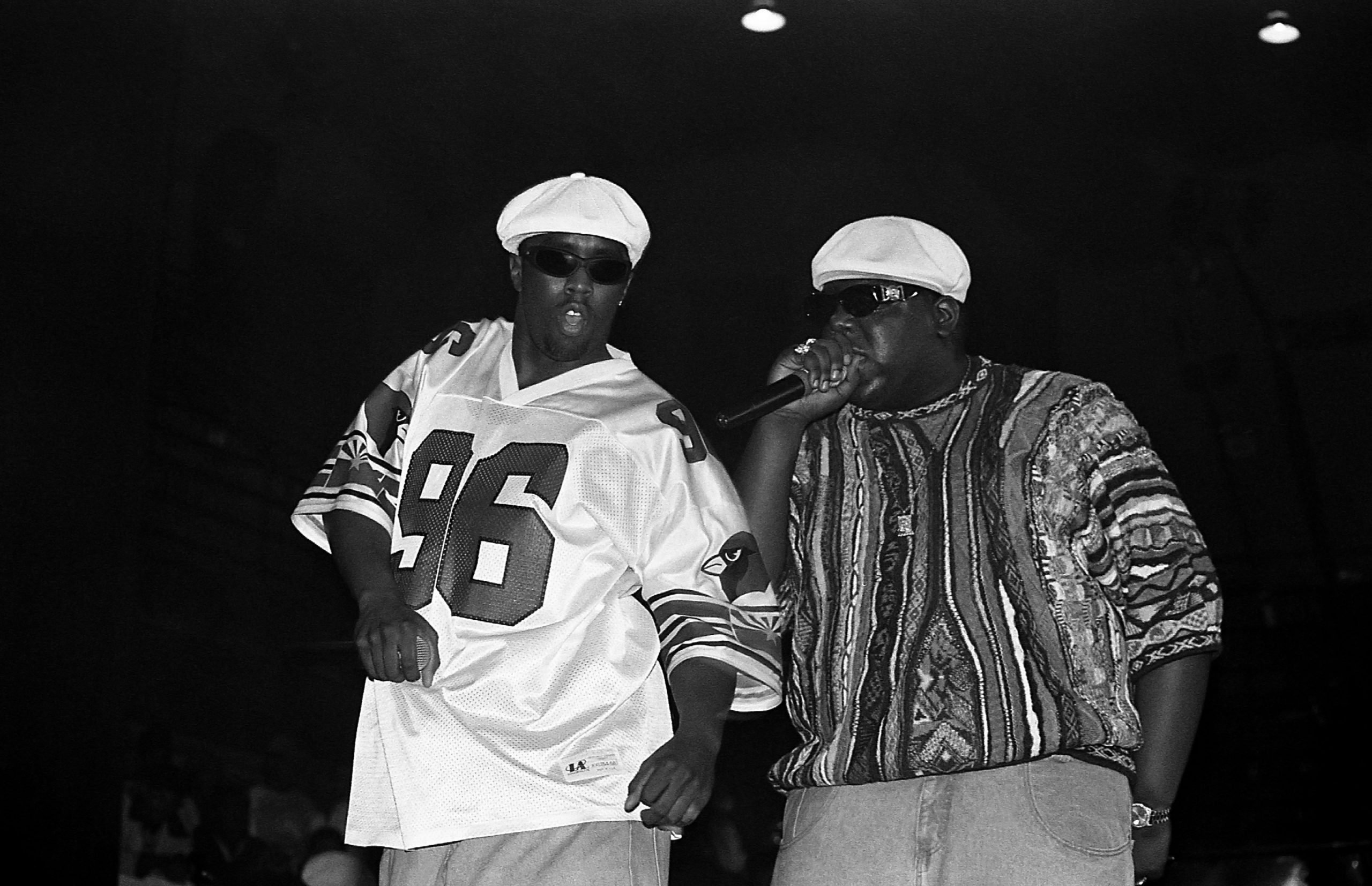 Sean 'Puffy' Combs and The Notorious B.I.G performing together wearing matching white hats