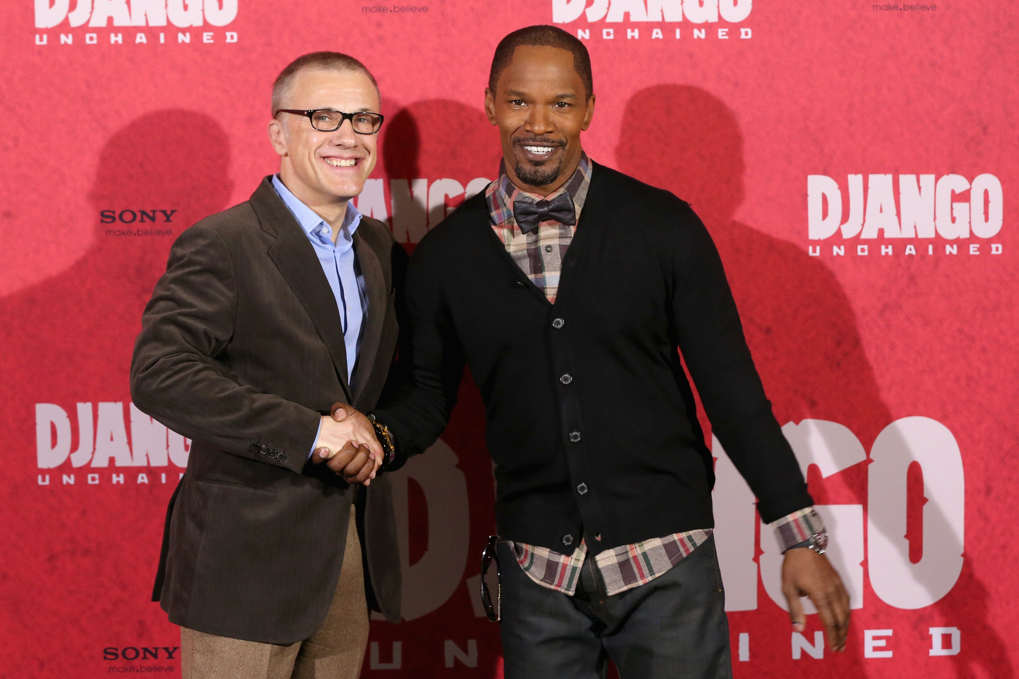 'Django Unchained' actors Christoph Waltz and Jamie Foxx, whose on-screen relationship developed a fan theory. The two actors shake hands while smiling in front of the step and repeat.