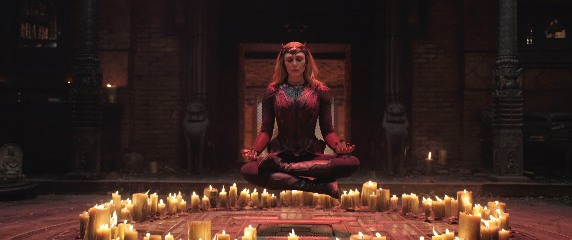 'Doctor Strange in the Multiverse of Madness' Elizabeth Olsen as Wanda Maximoff:Scarlet Witch levitating off the ground with her eyes closed with candles surrounding her in a circle