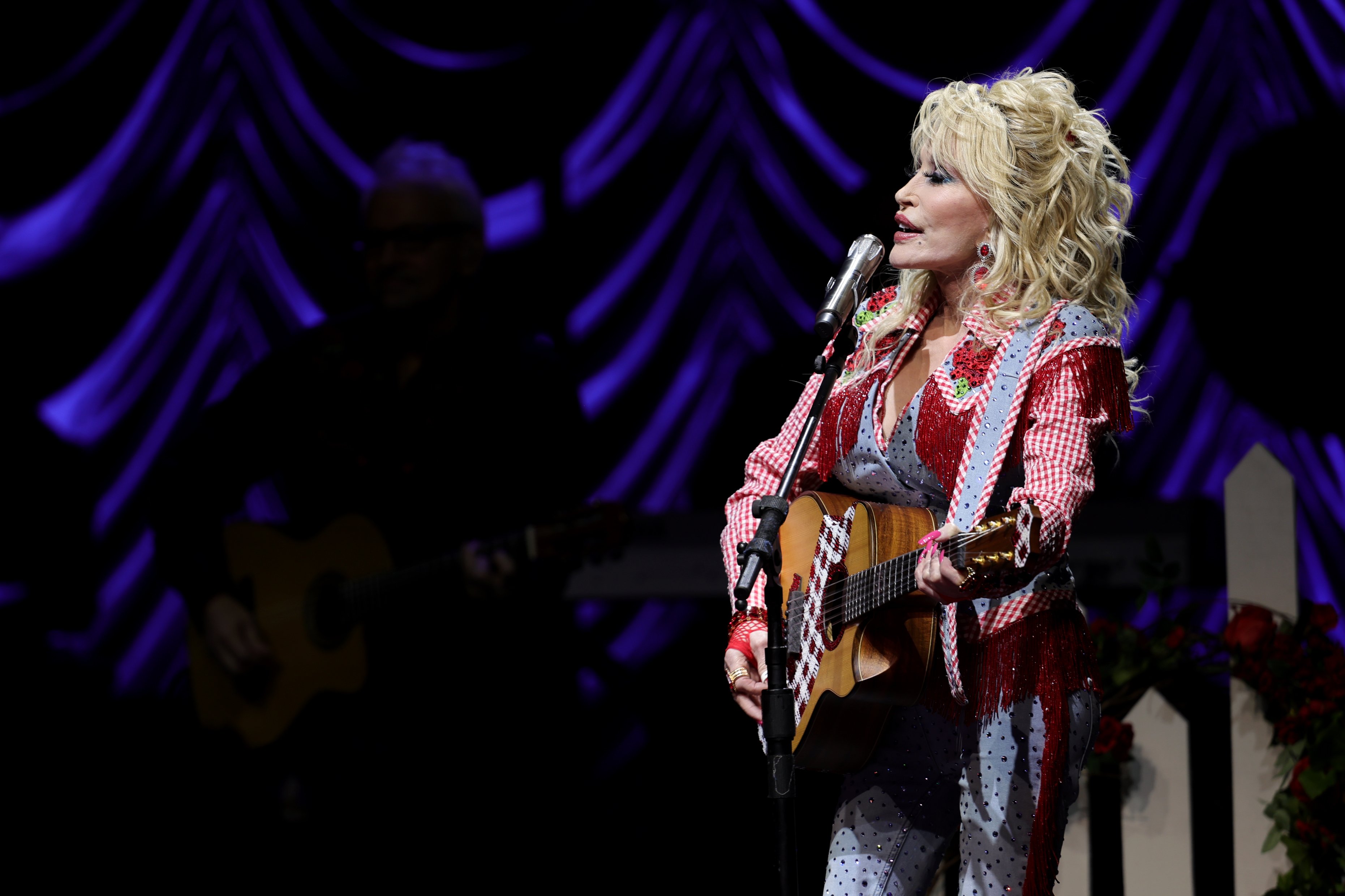 Dolly Parton, who was just inducted in the Rock & Roll Hall of Fame, singing on stage and playing guitar.