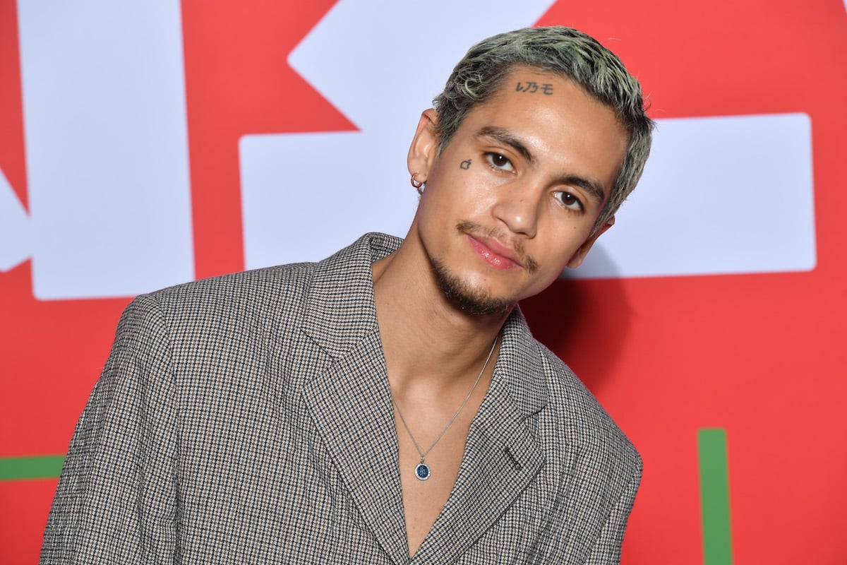 Euphoria actor Dominic Fike poses in a grey suit
