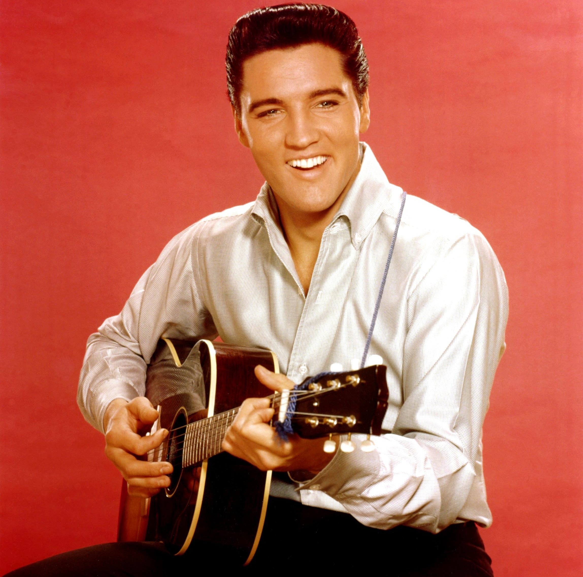 Elvis Presley playing songs on a guitar