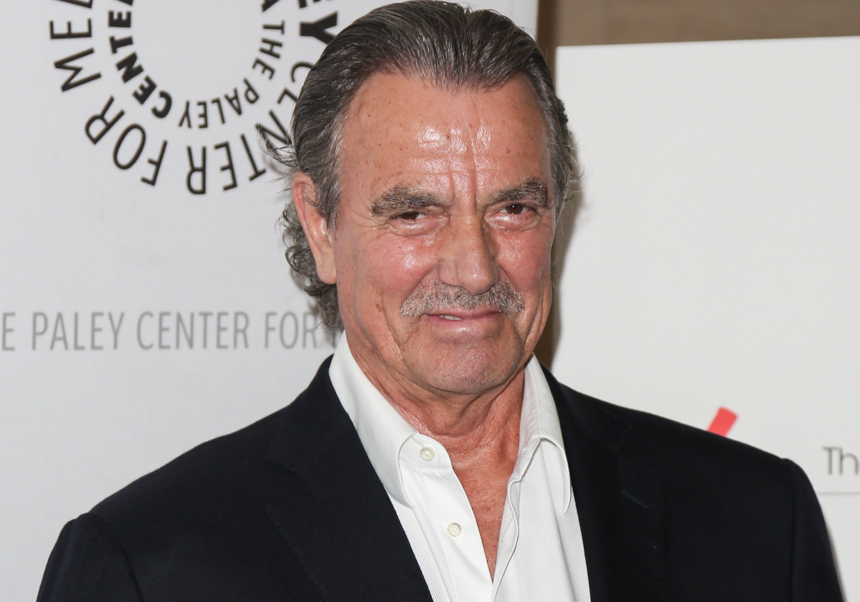 'The Young and the Restless' spoilers focus on Victor Newman, played by actor Eric Braeden seen wearing a white shirt and black suit during a red carpet appearance.