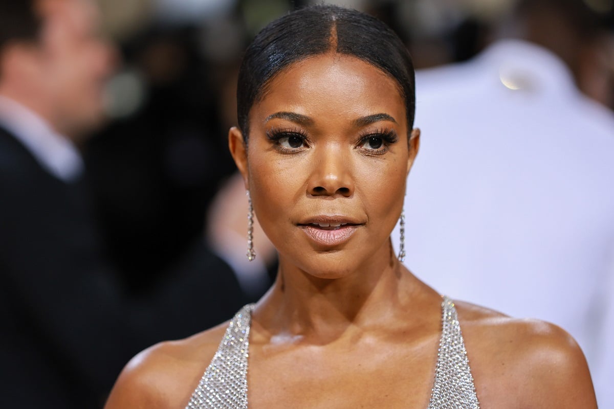 Gabrielle Union posing while wearing a silver dress.