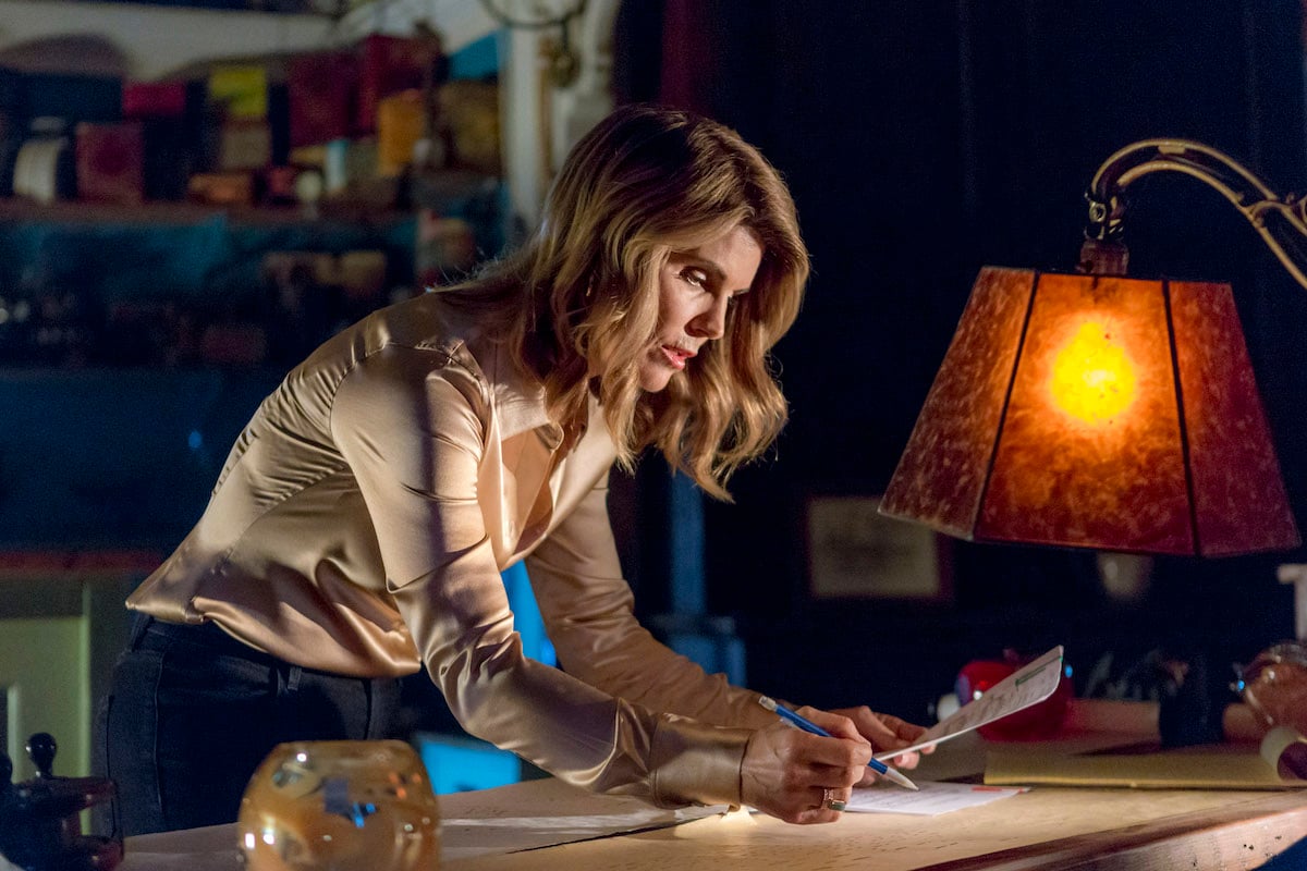 Lori Loughlin looking at a paper in an image from the canceled Hallmark series 'Garage Sale Mysteries'