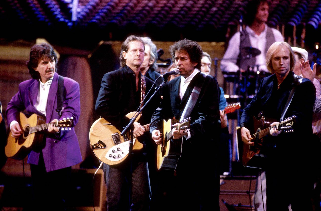 George Harrison, Bob Dylan, and Tom Petty of The Traveling Wilburys performing together in 1990.