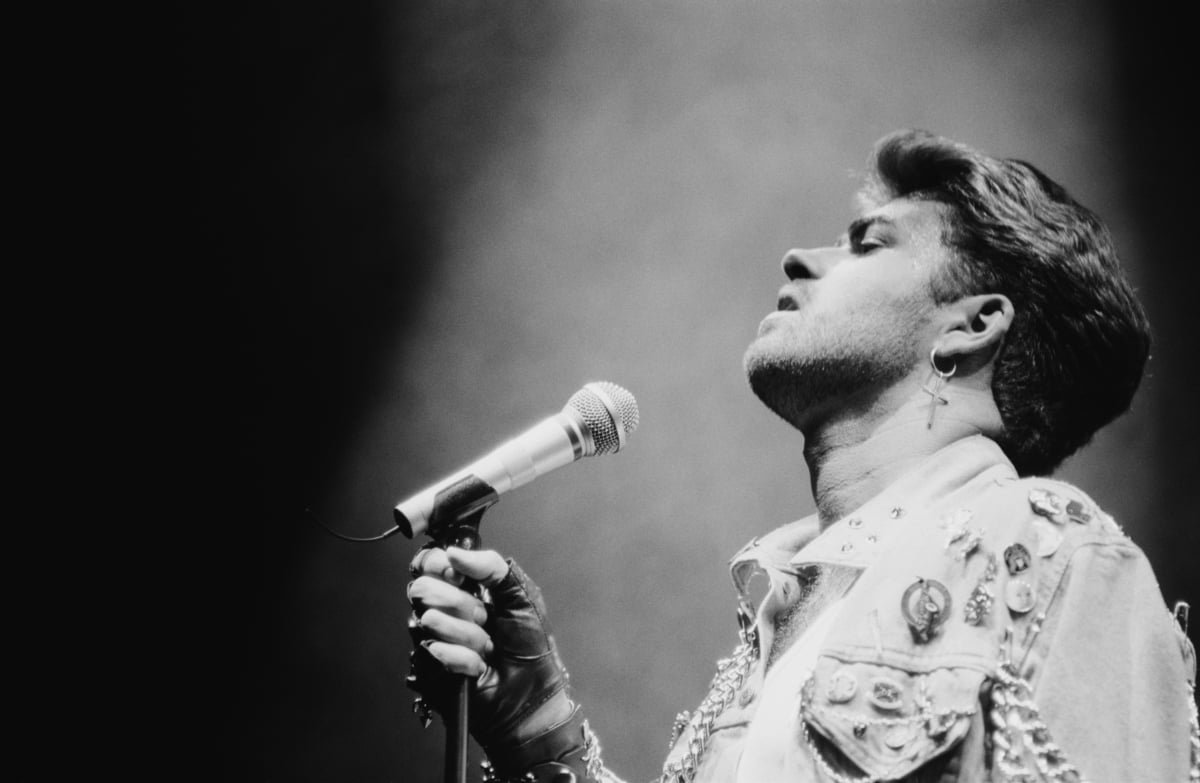 George Michael leans his head back while performing on stage during his 1988 'Faith' world tour.