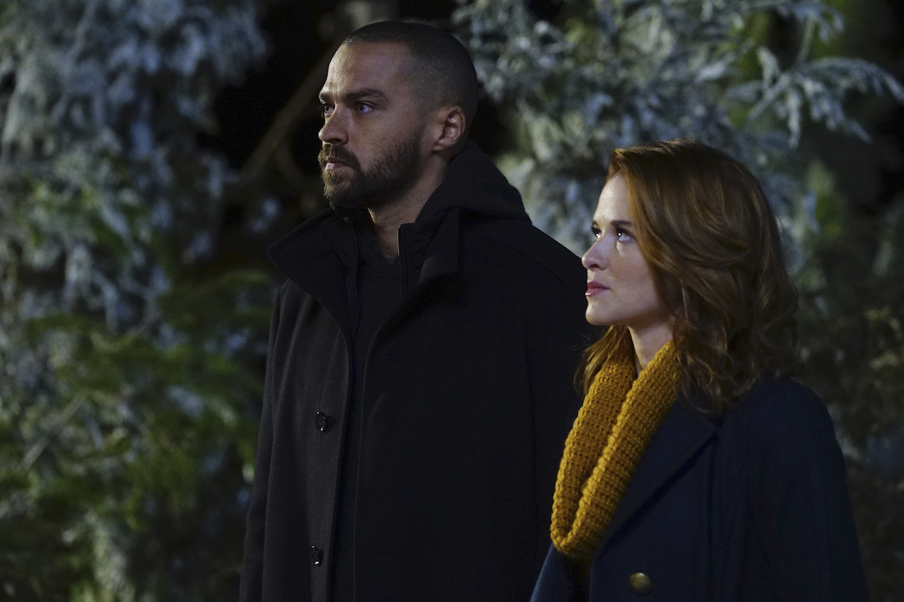 Jesse Williams as Jackson Avery and Sarah Drew as April Kepner stand outside together looking up in 'Grey's Anatomy'.