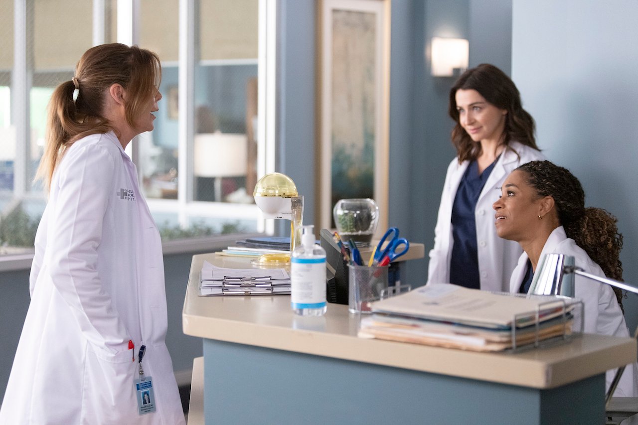 Meredith Grey (Ellen Pompeo) talks to Maggie Pierce (Kelly McCreary) in the hospital as Amelia Shepherd (Caterina Scorsone) looks on. 