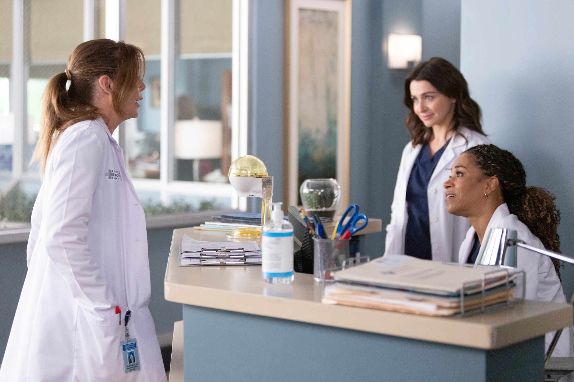 The doctors at Grey Sloan Memorial Hospital, who could be impacted by the choices teased in the preview for the 'Grey's Anatomy' Season 18 finale. They're standing around a desk wearing white lab coats.