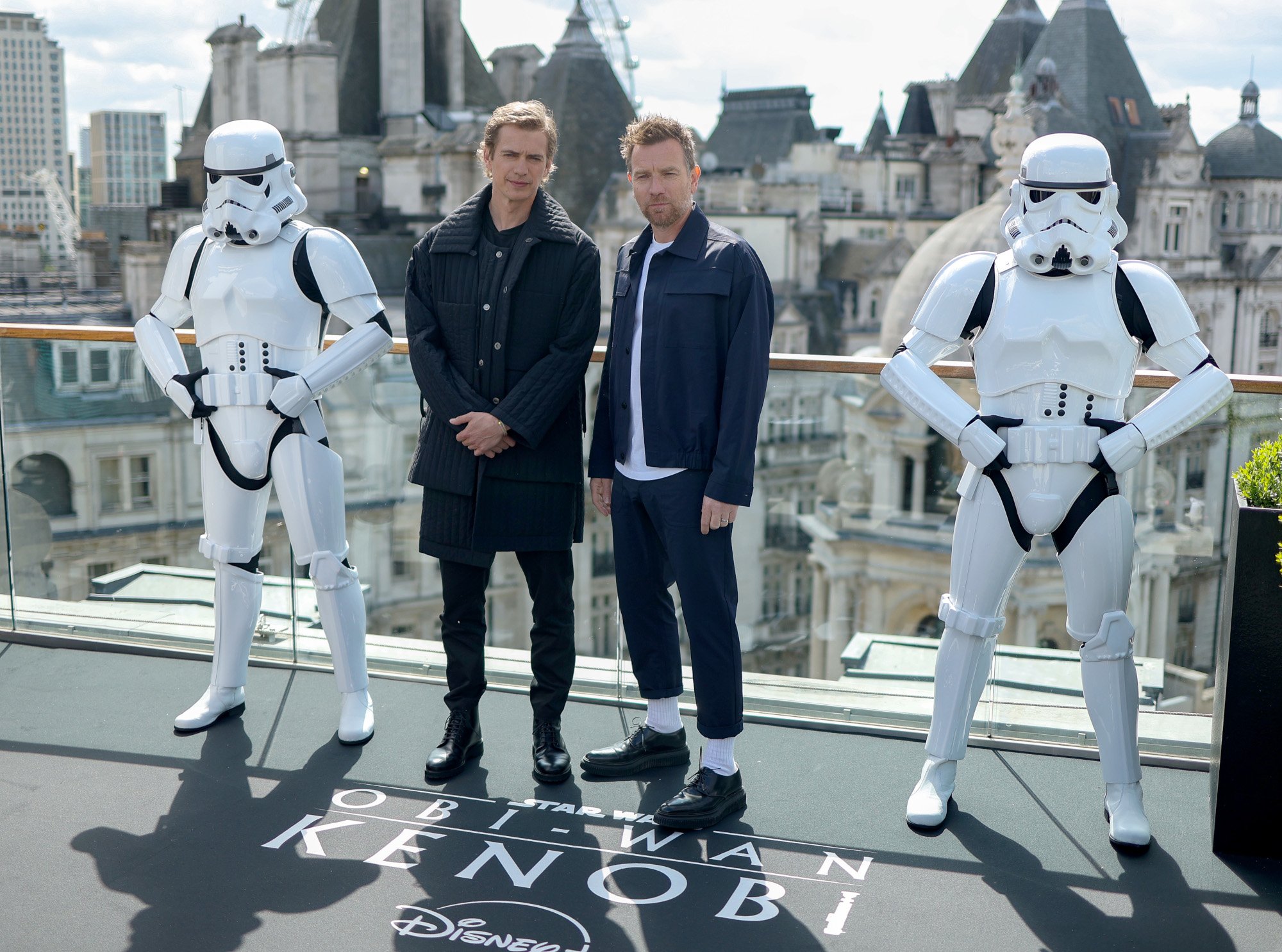 'Obi-Wan Kenobi' stars Hayden Christensen and Ewan McGregor, both of whom have very different net worths. They're standing between two Stomtroopers and smiling.