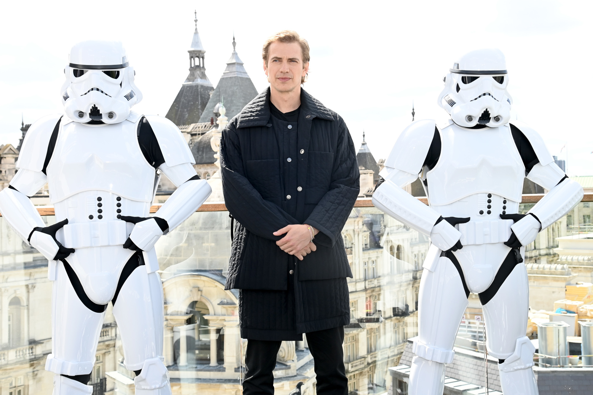 Hayden Christensen at the 'Obi-Wan Kenobi' photocall. He's standing between two Stormtroopers in a long, black jacket.