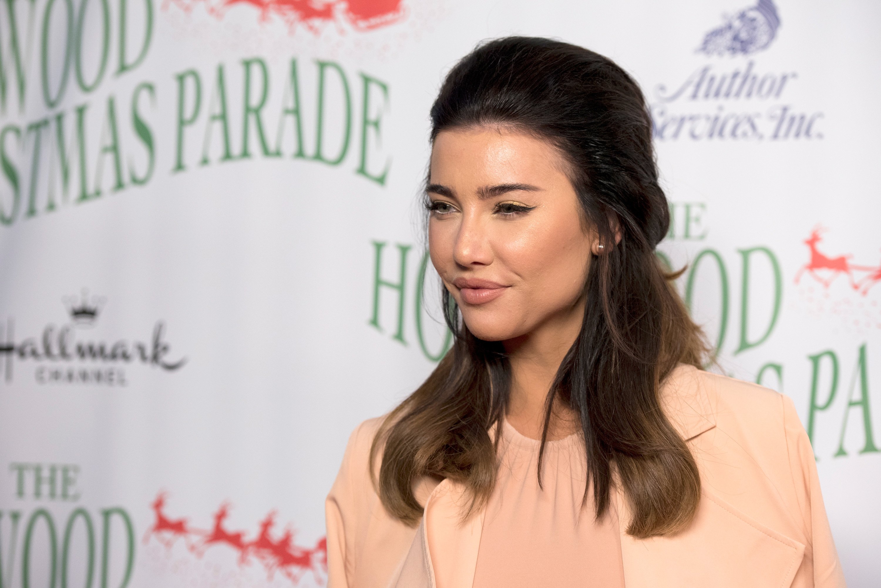 'The Bold and the Beautiful' star Jacqueline MacInnes Wood wearing a peach colored sweater and jacket during a Christmas parade.