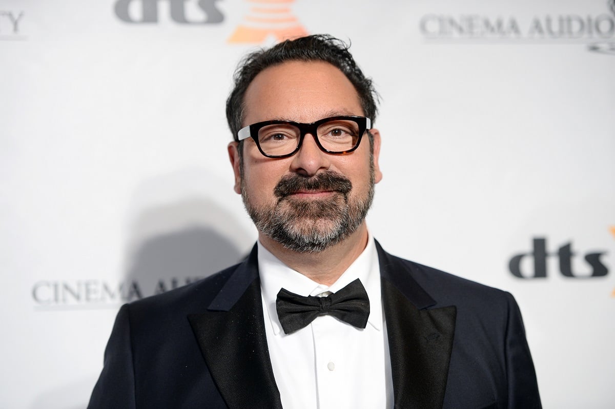 James Mangold smirking while wearing a suit and glasses.