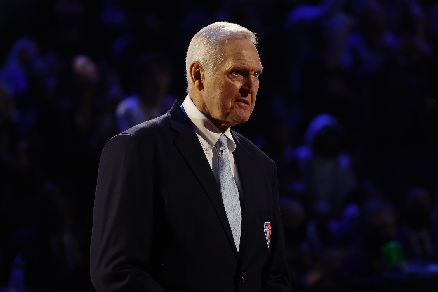 Jerry West standing in a suit on stage