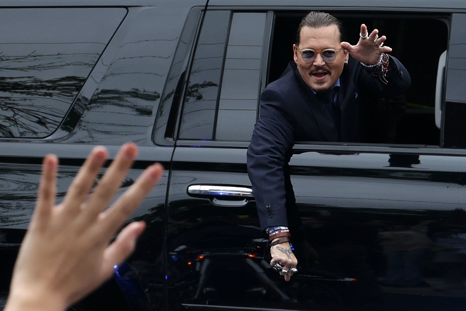 Johnny Depp waves to fans after being in court 