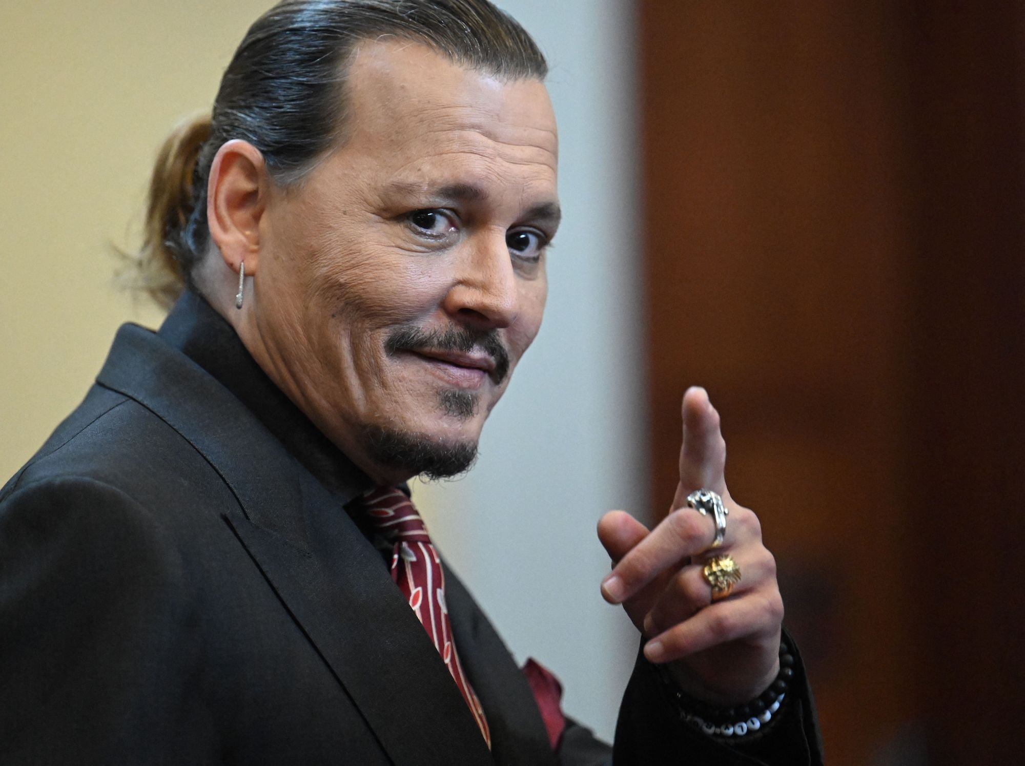 Johnny Depp, wearing a suit in court, won't look at Amber Heard.