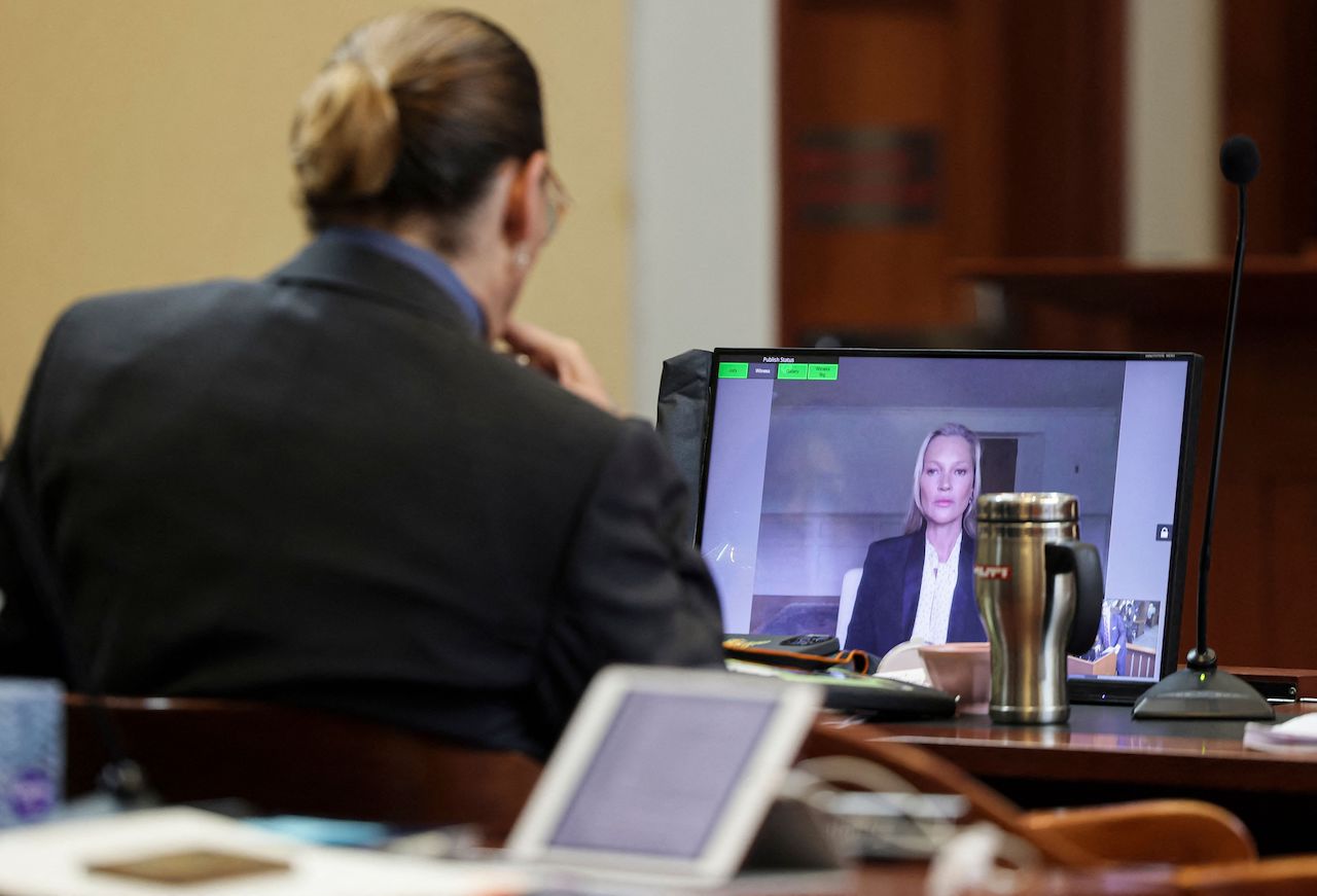 Johnny Depp listens as his former girlfriend, Model Kate Moss, testifies via video link at his trial