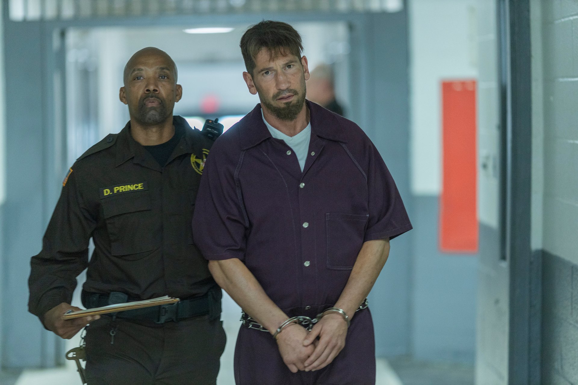 Jon Bernthal as Wayne Jenkins in a purple prison jumpsuit and handcuffs in 'We Own This City'