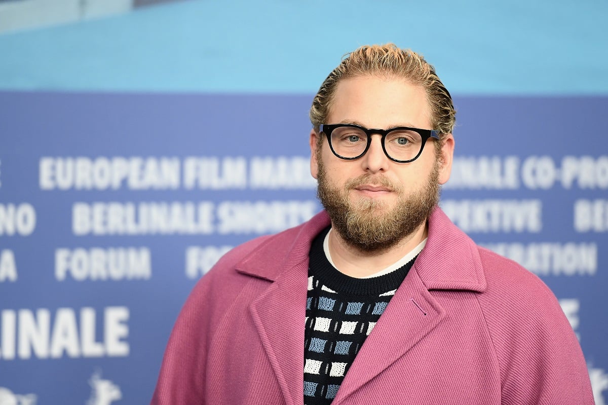 Jonah Hill posing while wearing a purple jacket.