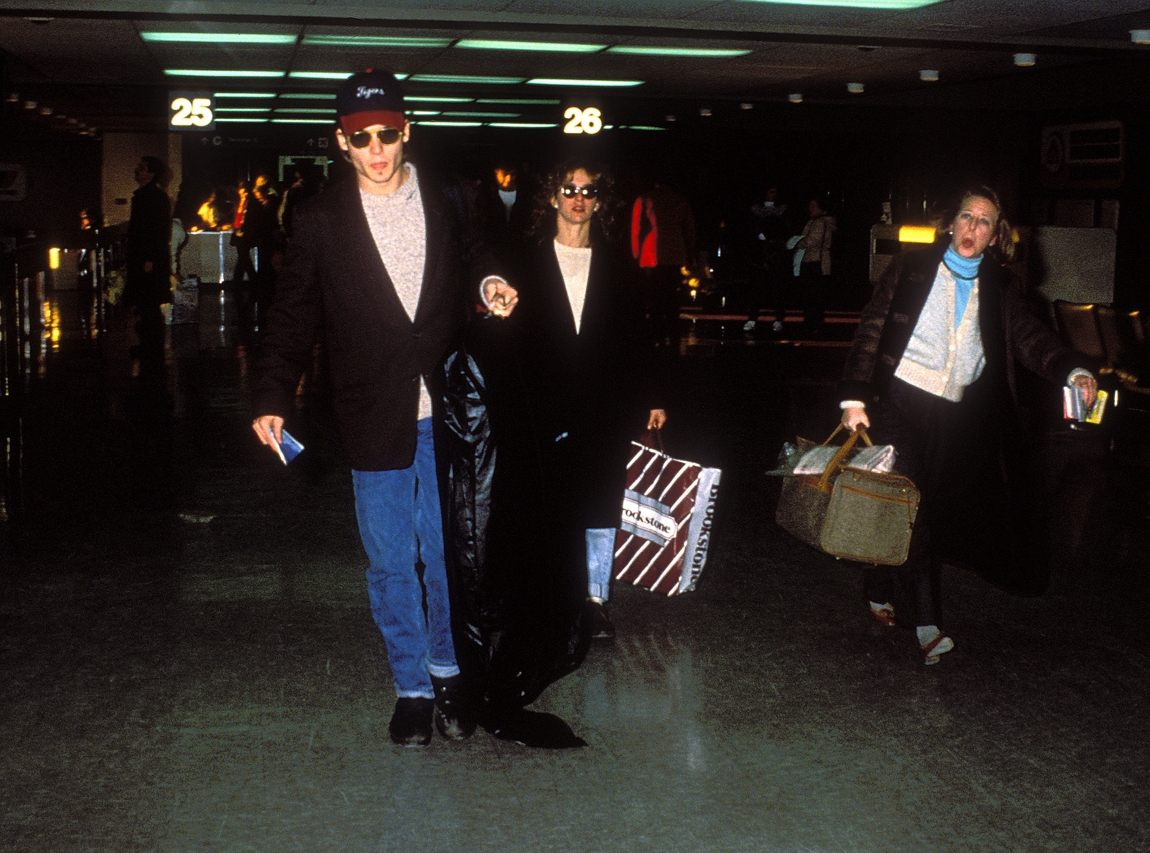 Johnny Depp and Jennifer Grey walk through the airport.