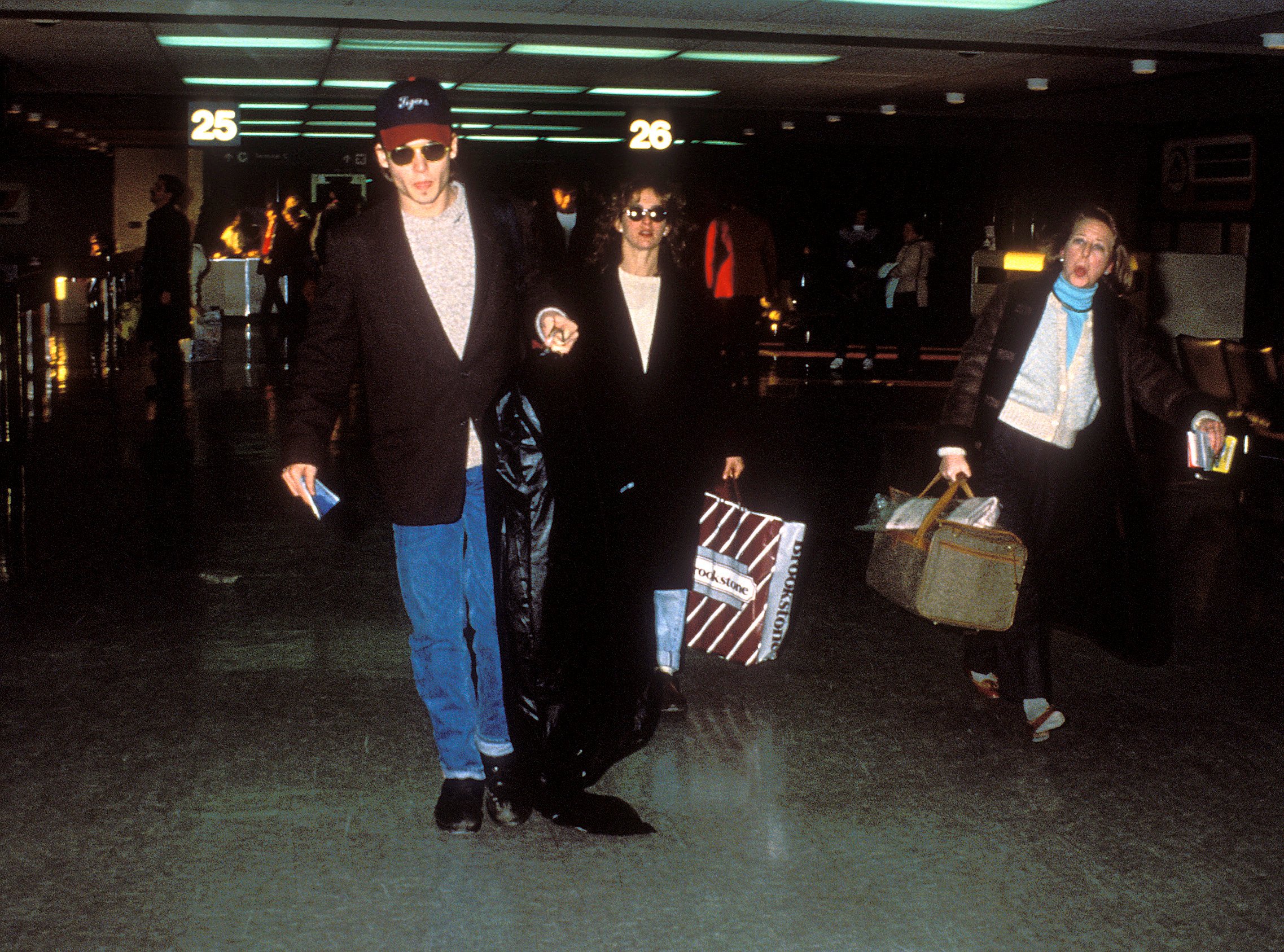 Johnny Depp and Jennifer Grey walk through the airport.