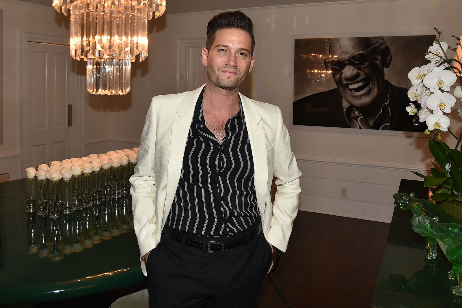 Josh Flagg from Million Dollar Listing smiles with hands in his pockets at a party 