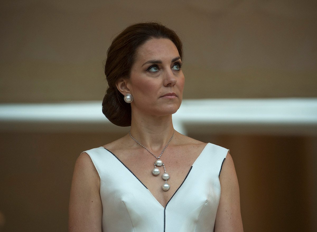 Kate Middleton, exhibiting what a body language expert describes as a 'thunder' facial expression, at a garden party in Poland