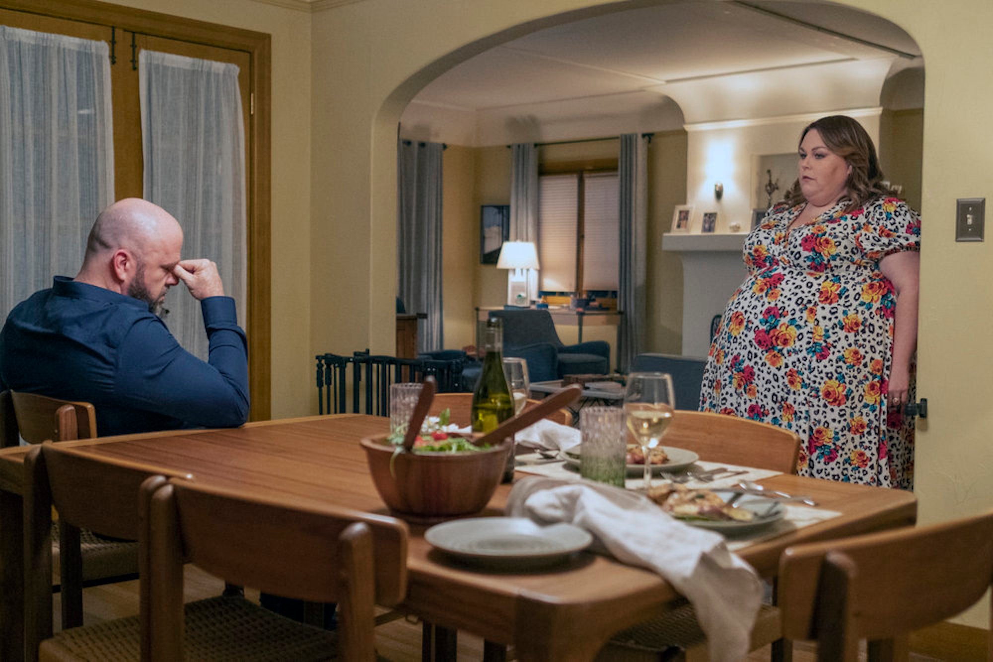 Kate and Toby in 'This Is Us' Season 6 standing on opposite sides of their dining room