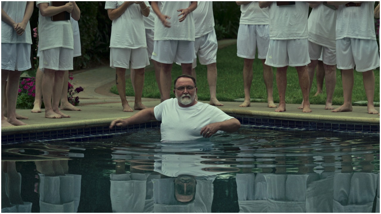 Keith Boyle as Dr. Donald Cline in a swimming pool with people surrounding him in Netflix's 'Our Father'