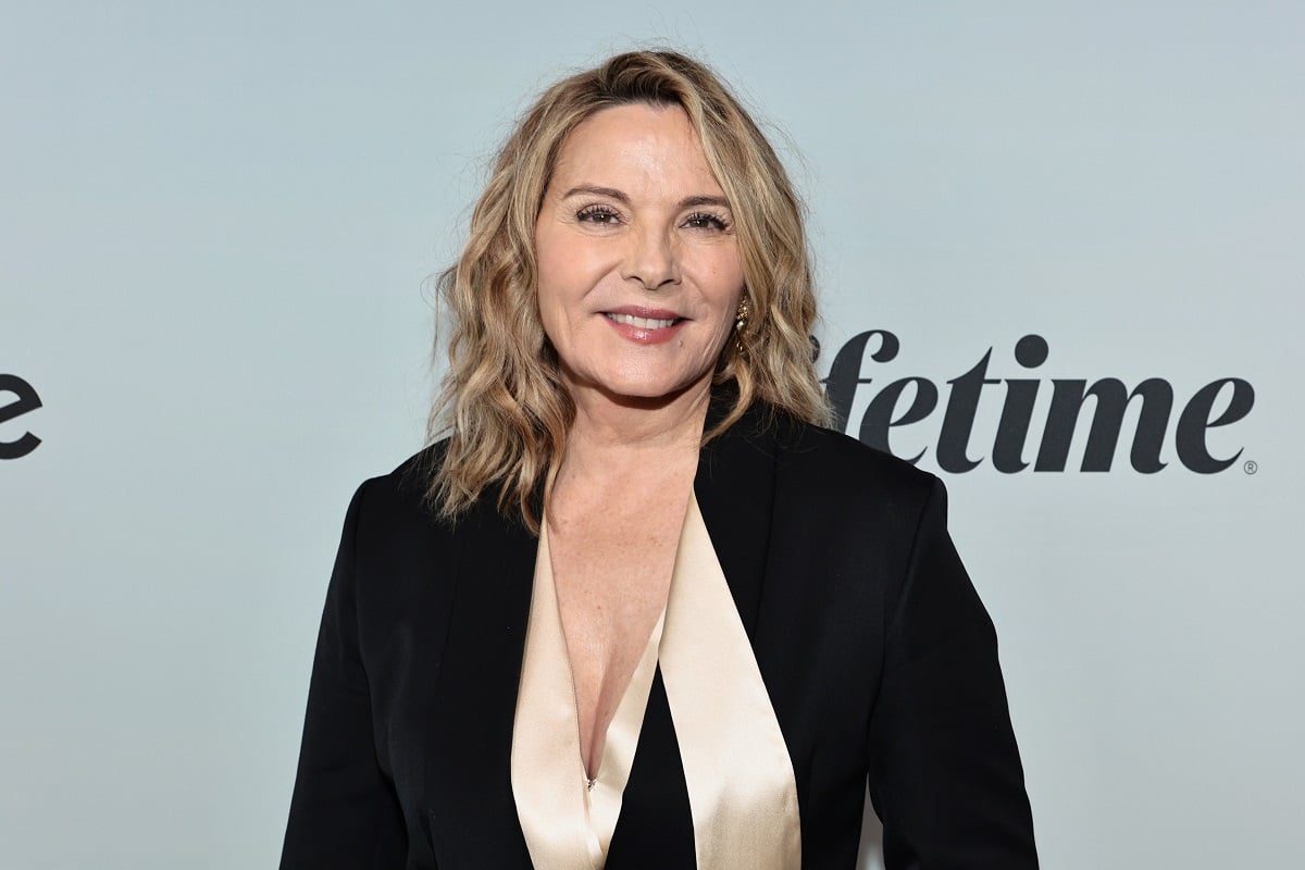 Kim Cattrall smiling while wearing a black dress.